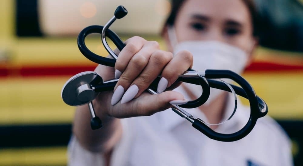Medical assistant holding stethoscope