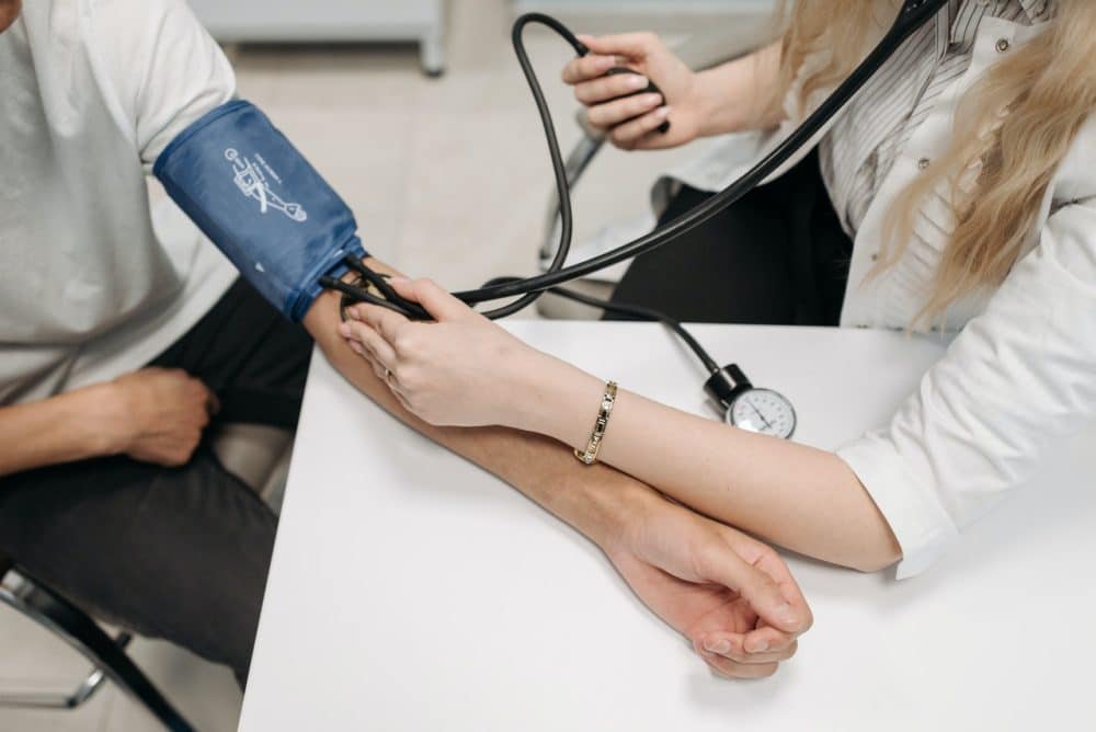 Medical assistant taking patient blood pressure